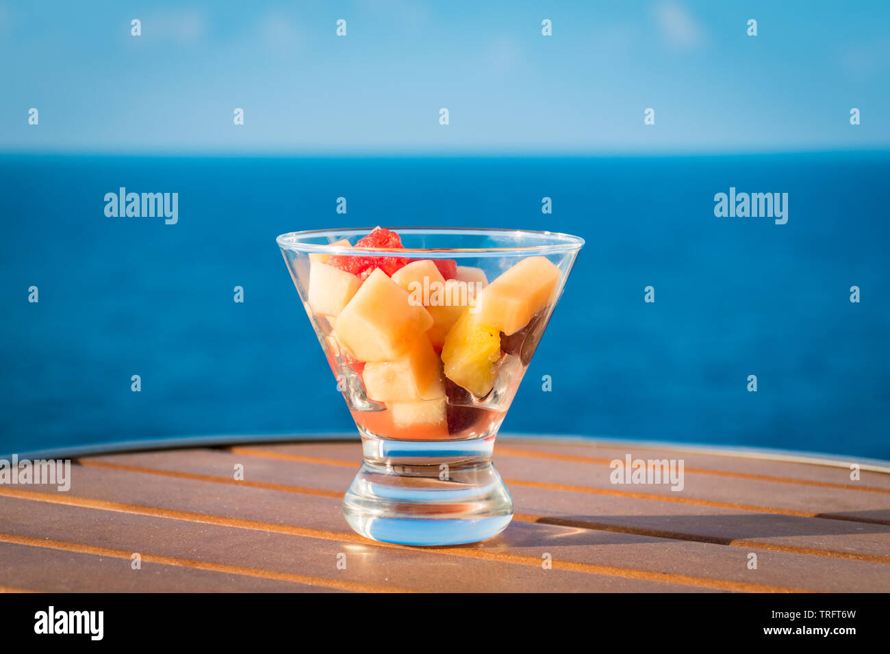 Salade de fruits sains dans bol en verre sur les vacances d'été. Fond de l'océan. Banque D'Images