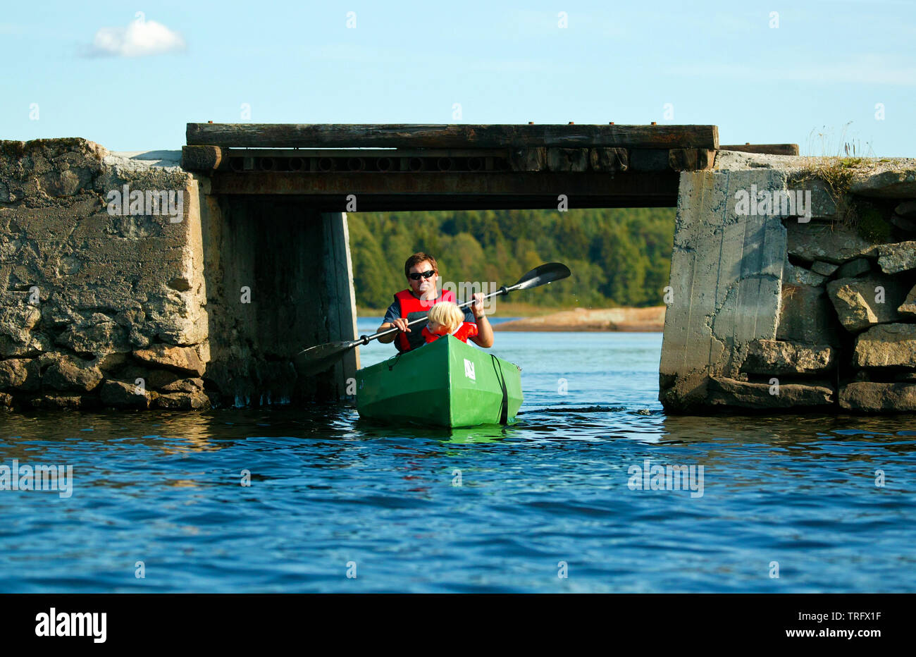 Père et fils dans un canot sur le lac Vansjø en Østfold, Norvège. Vansjø est le plus grand lac d'Østfold. Le pont est à la tête de l'île plus Oksenøya. Le lac Vansjø et ses lacs et rivières sont une partie de l'eau appelé système Morsavassdraget. Septembre, 2006. Banque D'Images