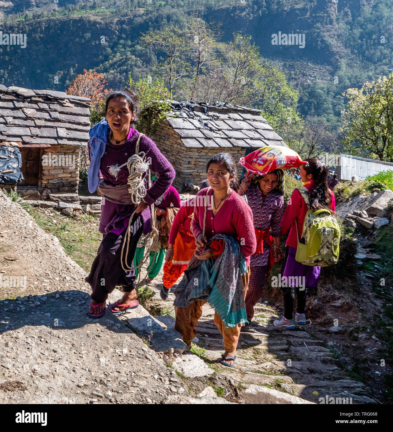 Happy smiling les femmes et les enfants de grimper le chemin escarpé à l'école dans le village de Supi dans l'Uttarakhand Himalaya de l'Inde du Nord Banque D'Images