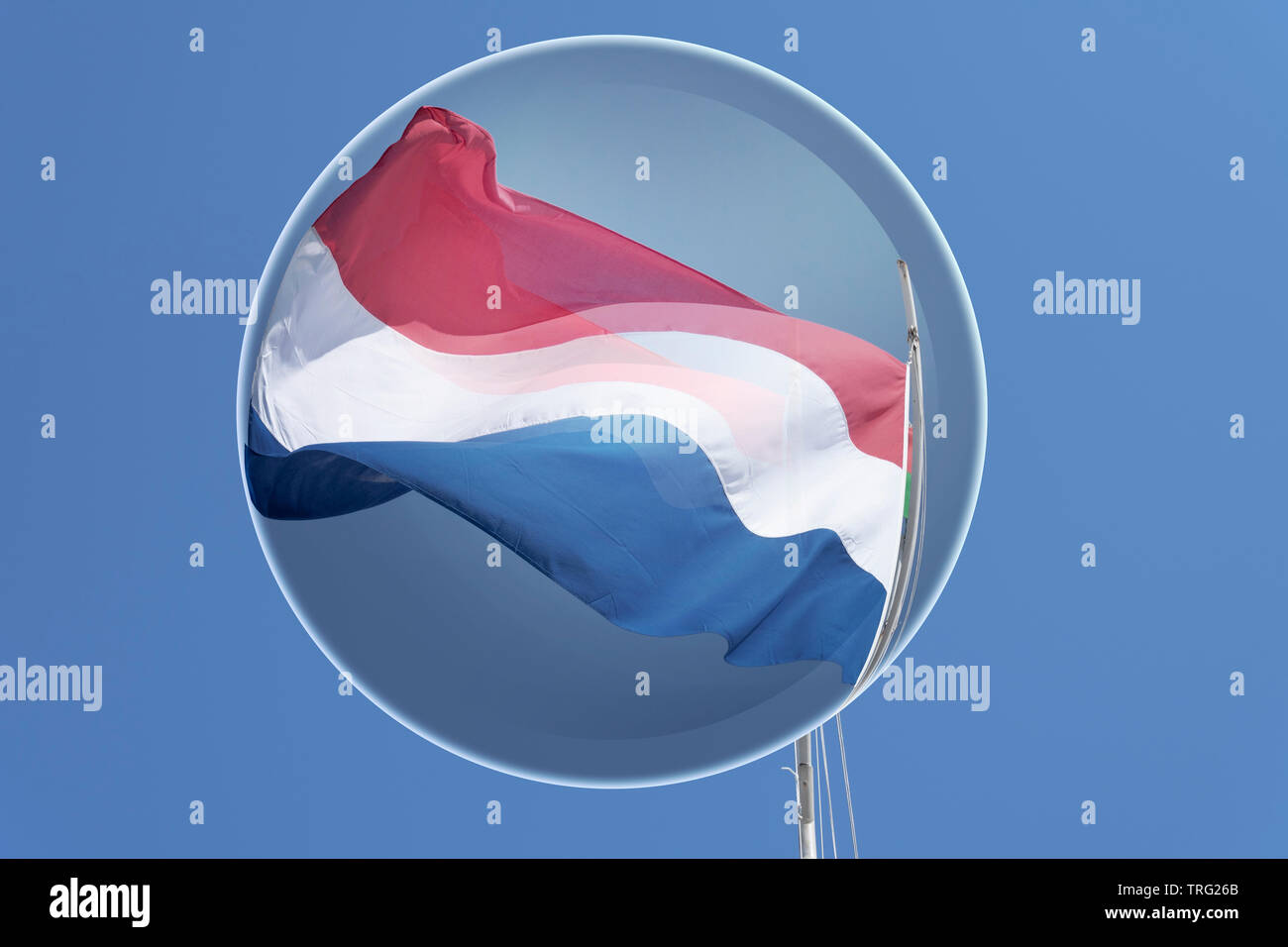 Drapeau de Pays-Bas dans le vent avec un joli fond bleu, photo prise à la verticale reflétée par une boule de chrystal Banque D'Images