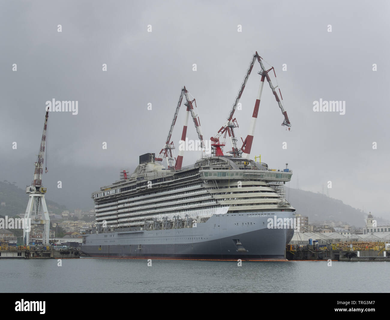 Italie Gênes le 19 mai 2019  : nouveau navire de croisière en construction dame écarlate amarré à un quai d'un chantier naval avec grandes grues Banque D'Images