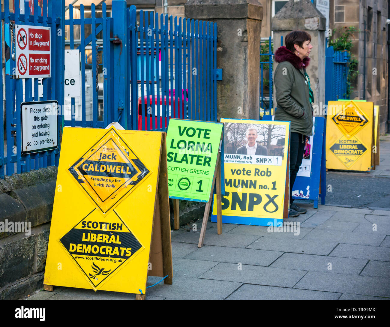 Homme marchant passé Lorne l'école primaire de scrutin à l'élection partielle du Conseil de Leith Walk, Edinburgh, Scotland, UK avec les conseils politiques de parti Banque D'Images