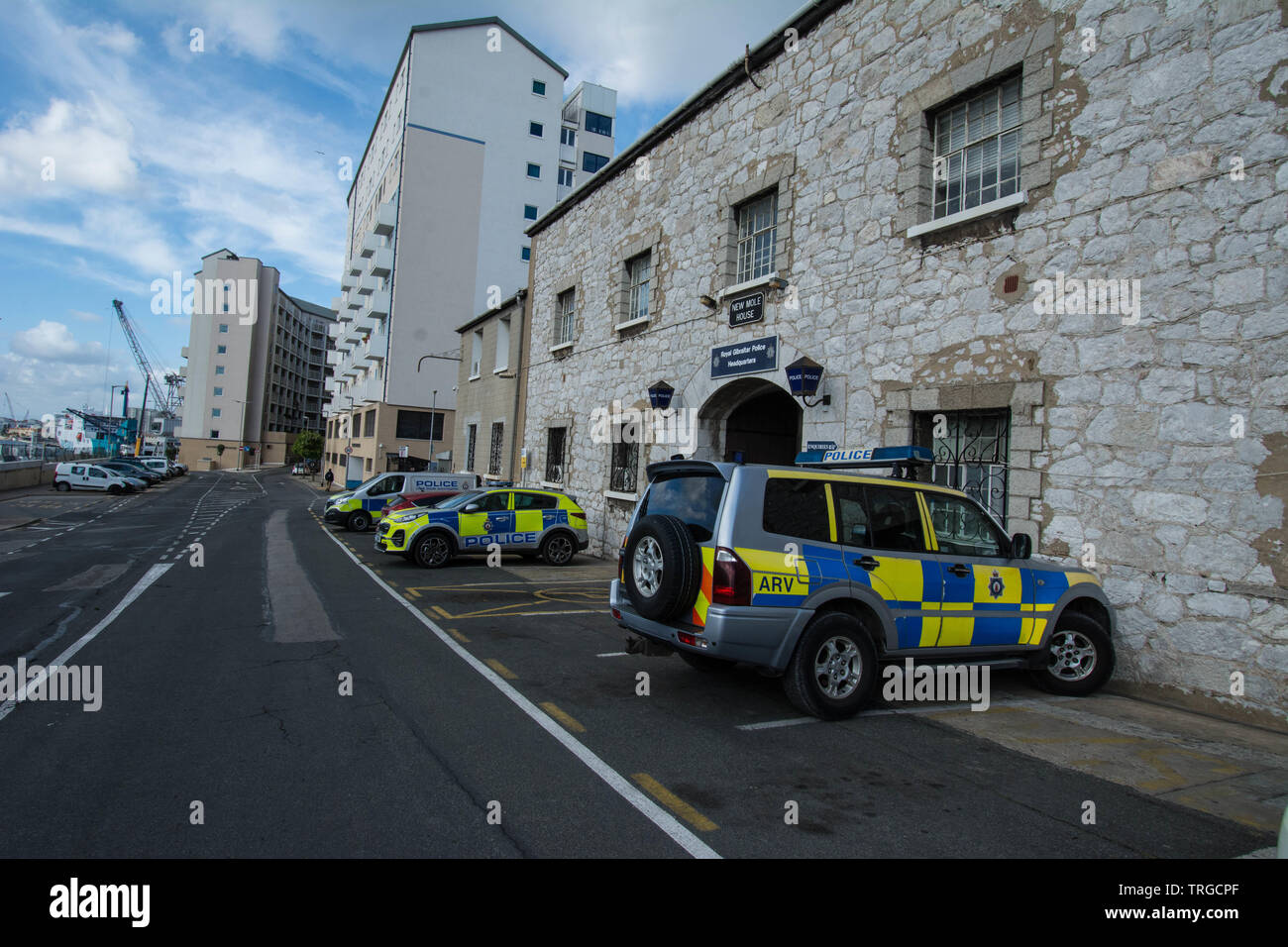 Voiture de police et poste de police à Gibraltar arche d'entrée voitures murs de pierre grue docks eau mer nuages espace prison espaces chemin chemin tarmac chemin Banque D'Images