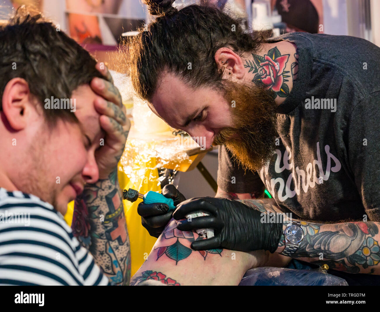 Corn Exchange, Édimbourg, Écosse, Royaume-Uni, 9e Convention de Tatouage écossais : passionnés et artistes tatoueurs avec présence faire un tatouage Banque D'Images