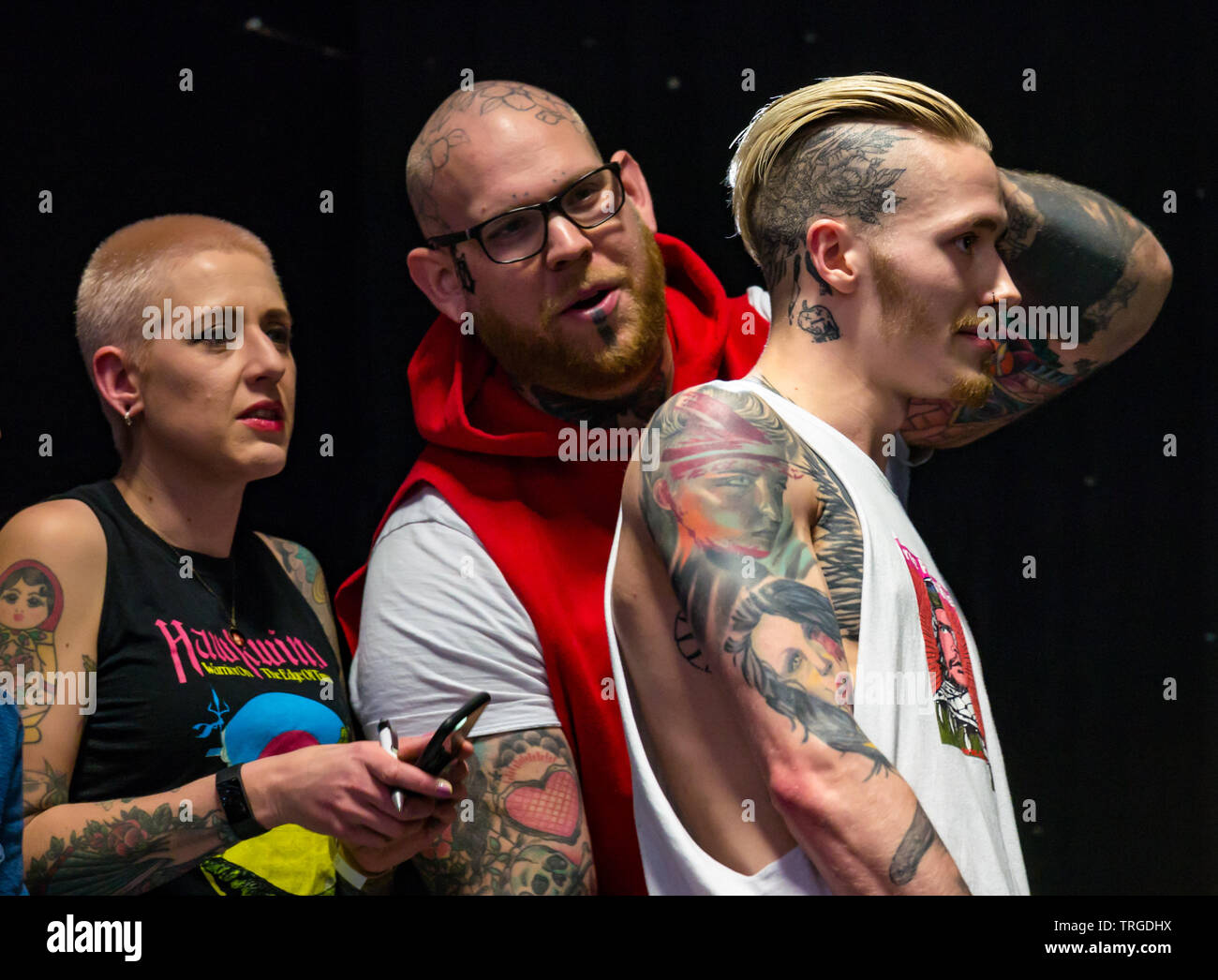 Corn Exchange, Édimbourg, Écosse, Royaume-Uni, 9e Convention de Tatouage écossais : les juges d'examiner de près du cou d'un homme dans un concours de tatouage Banque D'Images