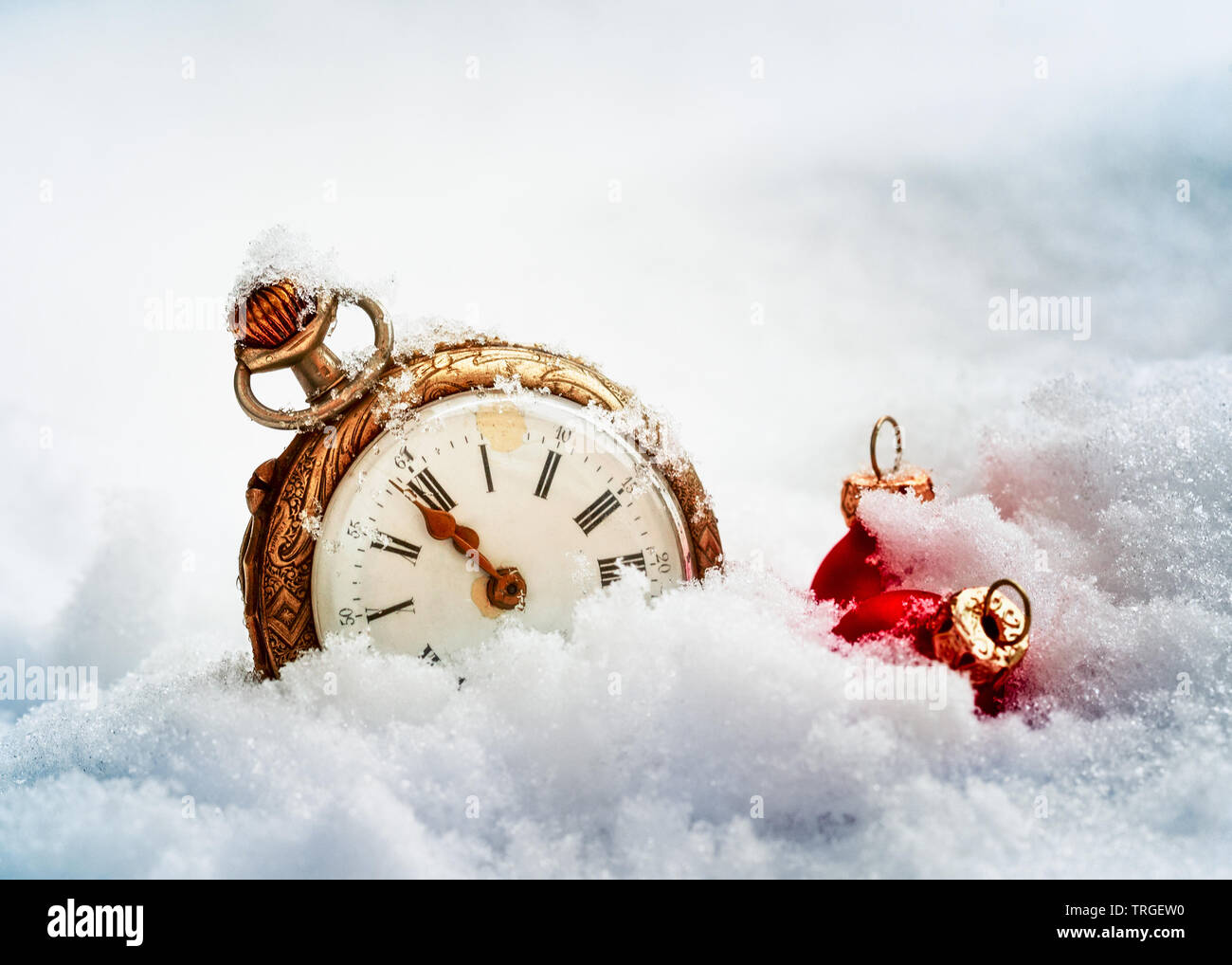 Nouvelle année réveil avant minuit. Montre de poche antique et boules de Noël rouge dans la neige. Concept de vacances Banque D'Images