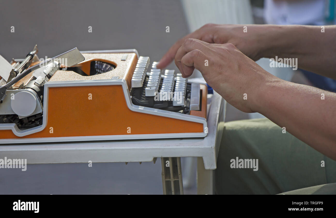 Jeune homme travaillant sur la vieille machine à écrire manuelle vintage Banque D'Images