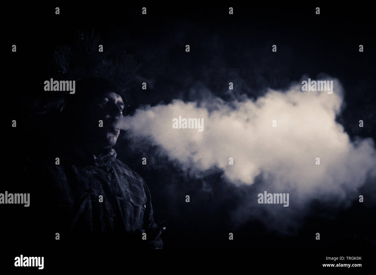 Hot man smoking la nuit de faire un gros effet de fumée en contre-jour Banque D'Images