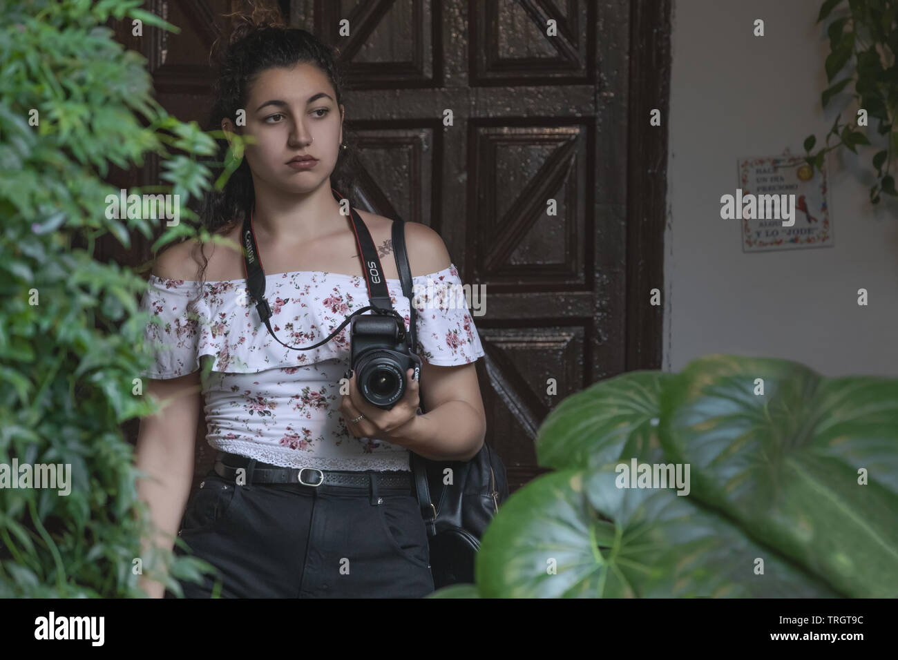 Cordoue, Espagne - 16 mai 2019 : Une jeune femme photographe tenant un appareil photo Canon dans un patio Cordovan Banque D'Images