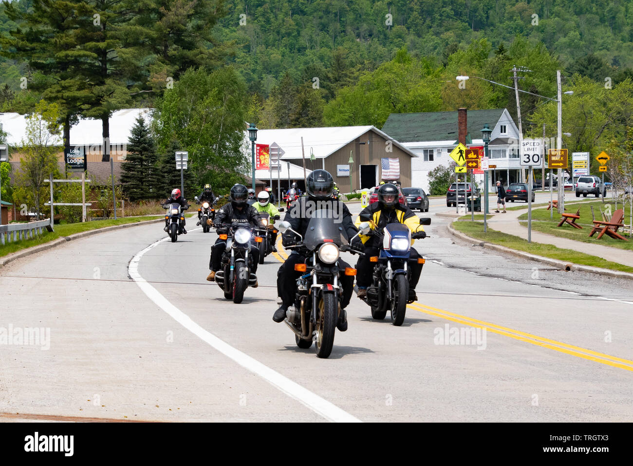 Un groupe de motos qui traversent le village de spéculateur, NY USA sur une promenade dans les montagnes Adirondack dans le cadre d'Americade 2019. Banque D'Images