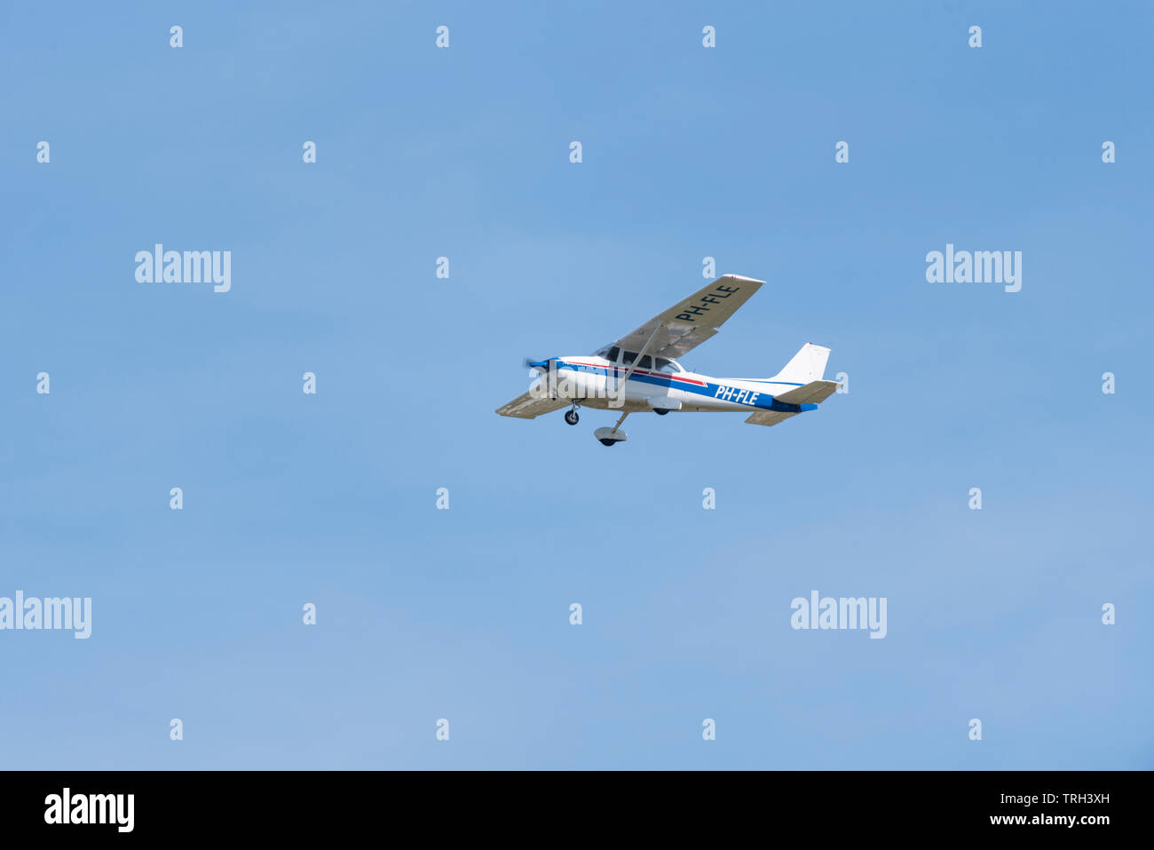 Avion léger Cessna F172N Skyhawk C172 pH-FLE de Reims volant dans un ciel bleu au-dessus de l'aéroport de Southend, Essex, Royaume-Uni Banque D'Images