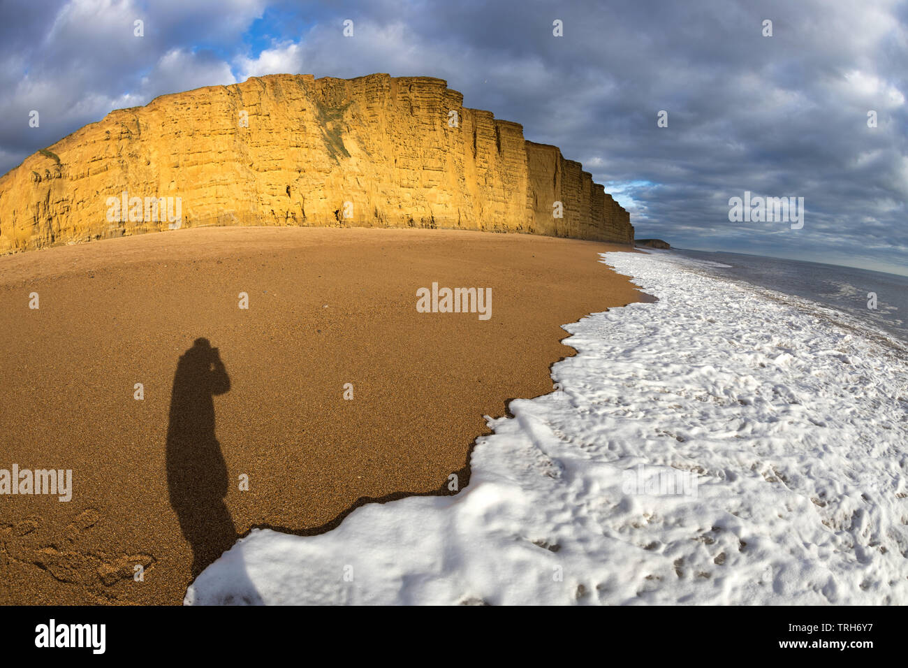 Vagues se brisant sur la plage sous les falaises de l'Est, West Bay, sur la côte jurassique, Dorset, England, UK Banque D'Images