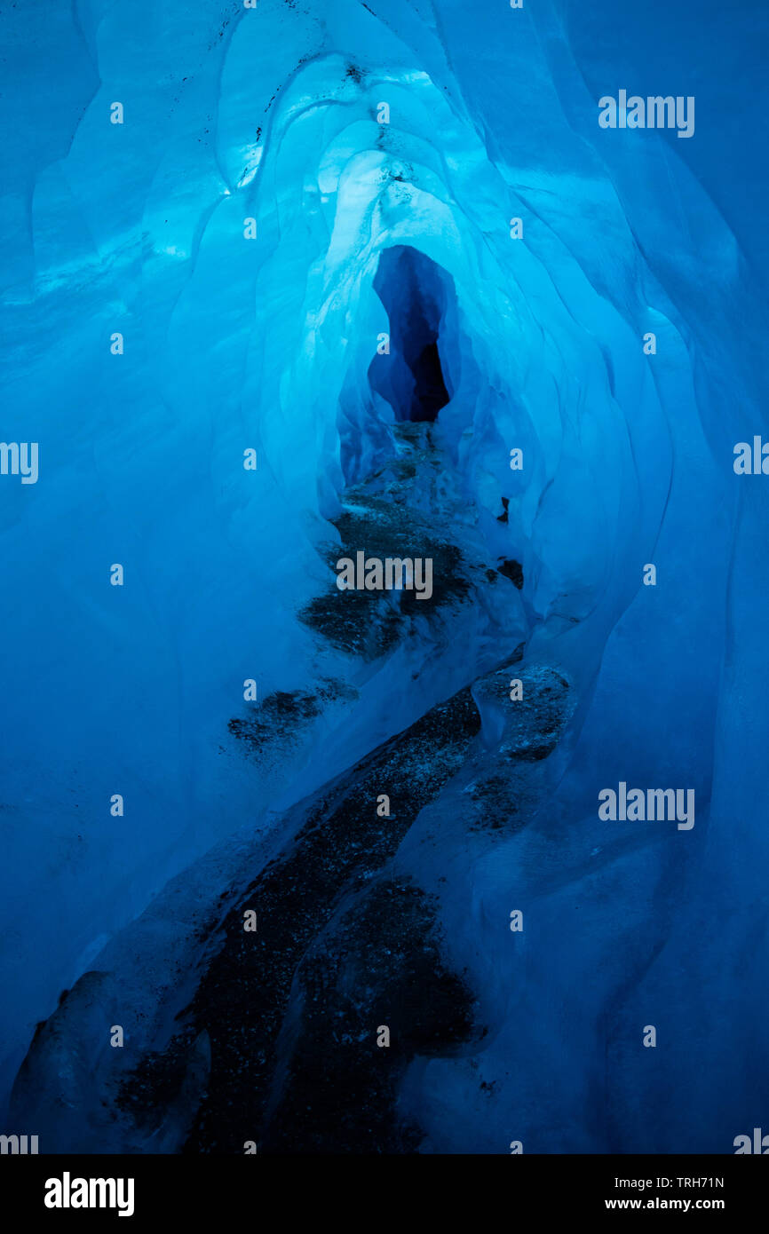 Grotte de glace sous la glace de la Matanuska Glacier en Alaska. Tunnel étroit avec lumière bleu brillant dans le cadre d'épaisseur de la glace de glacier. Banque D'Images