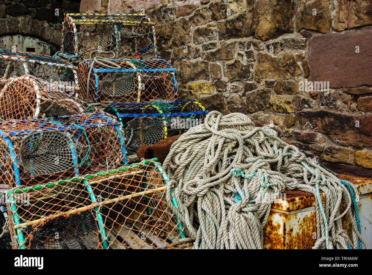 Des casiers à homard et crabe avec des filets de pêche sur le quai au port de Beadnell, Northumberland, Angleterre Banque D'Images