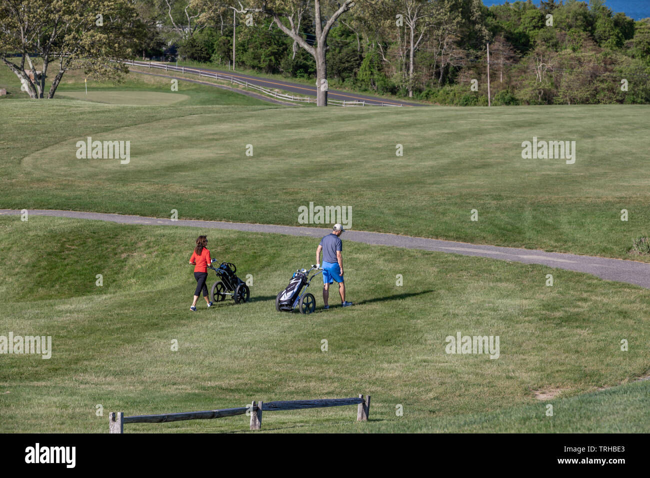 Un couple en train de marcher le fairway à Gardiners Bay Country Club de Shelter Island, NY Banque D'Images