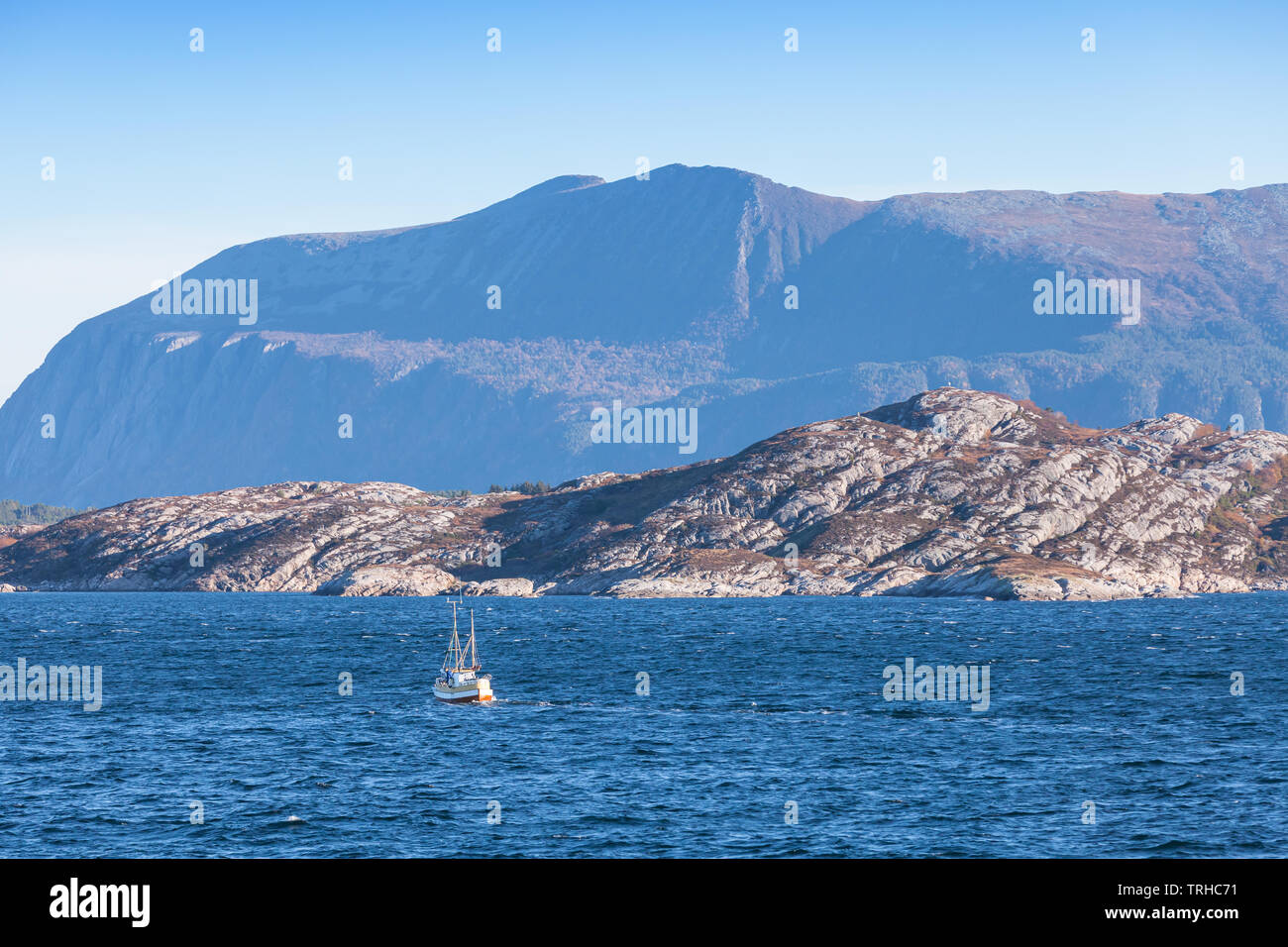 Petit bateau de pêche est en mer de Norvège près de montagnes côtières, région de Trondheim, Norvège Banque D'Images