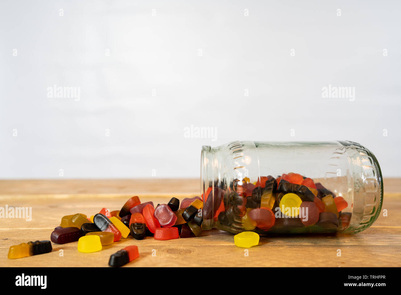 Bocal de bonbons de son côté. Candy du pot sur la table en bois. fond blanc Banque D'Images