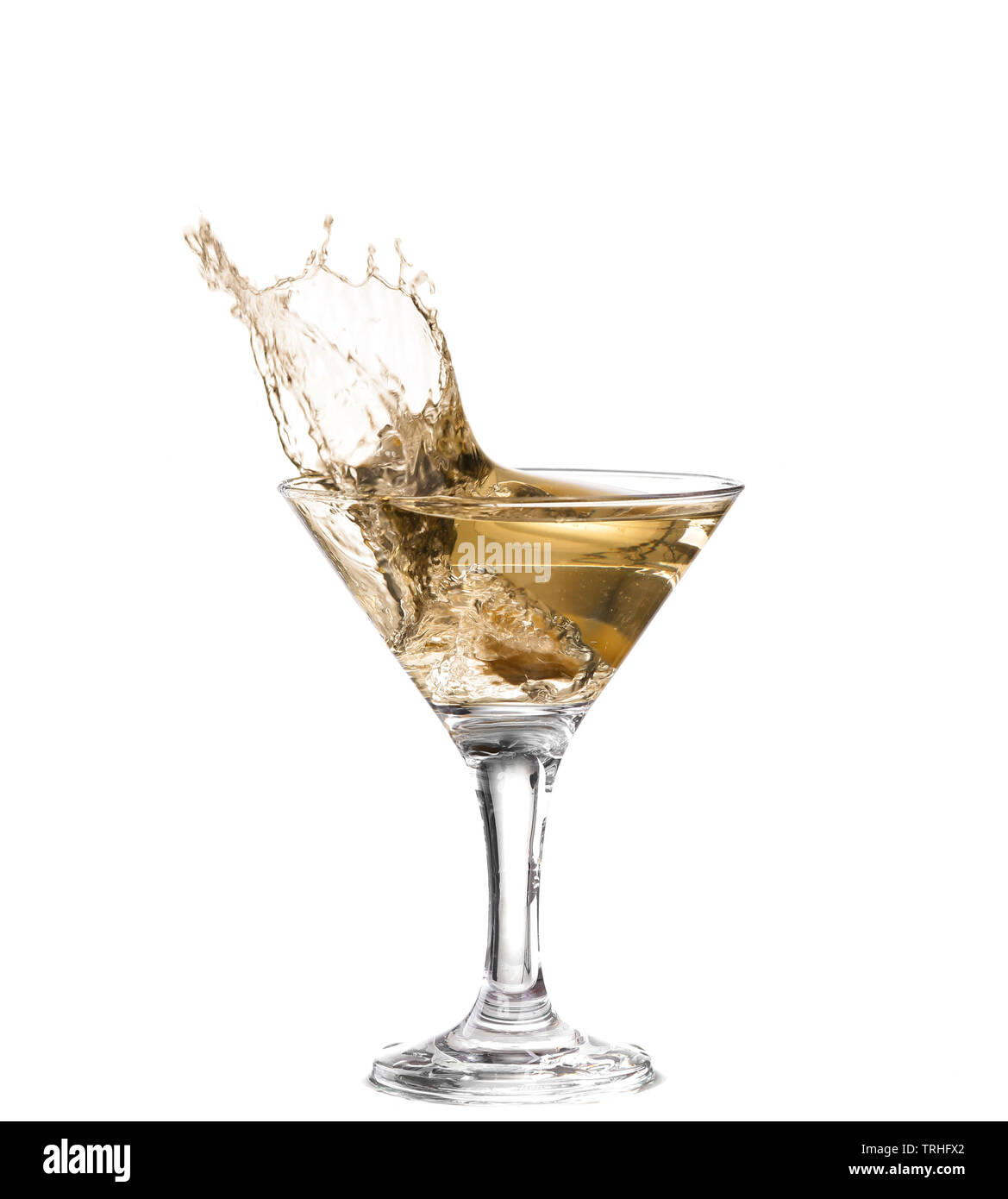 Un verre à martini sur un fond blanc ; les ondulations de l'eau et d'éclaboussures  comme un espagnol vert olive avec pimento est tombé dans le verre ; forme  horizontale Photo Stock -