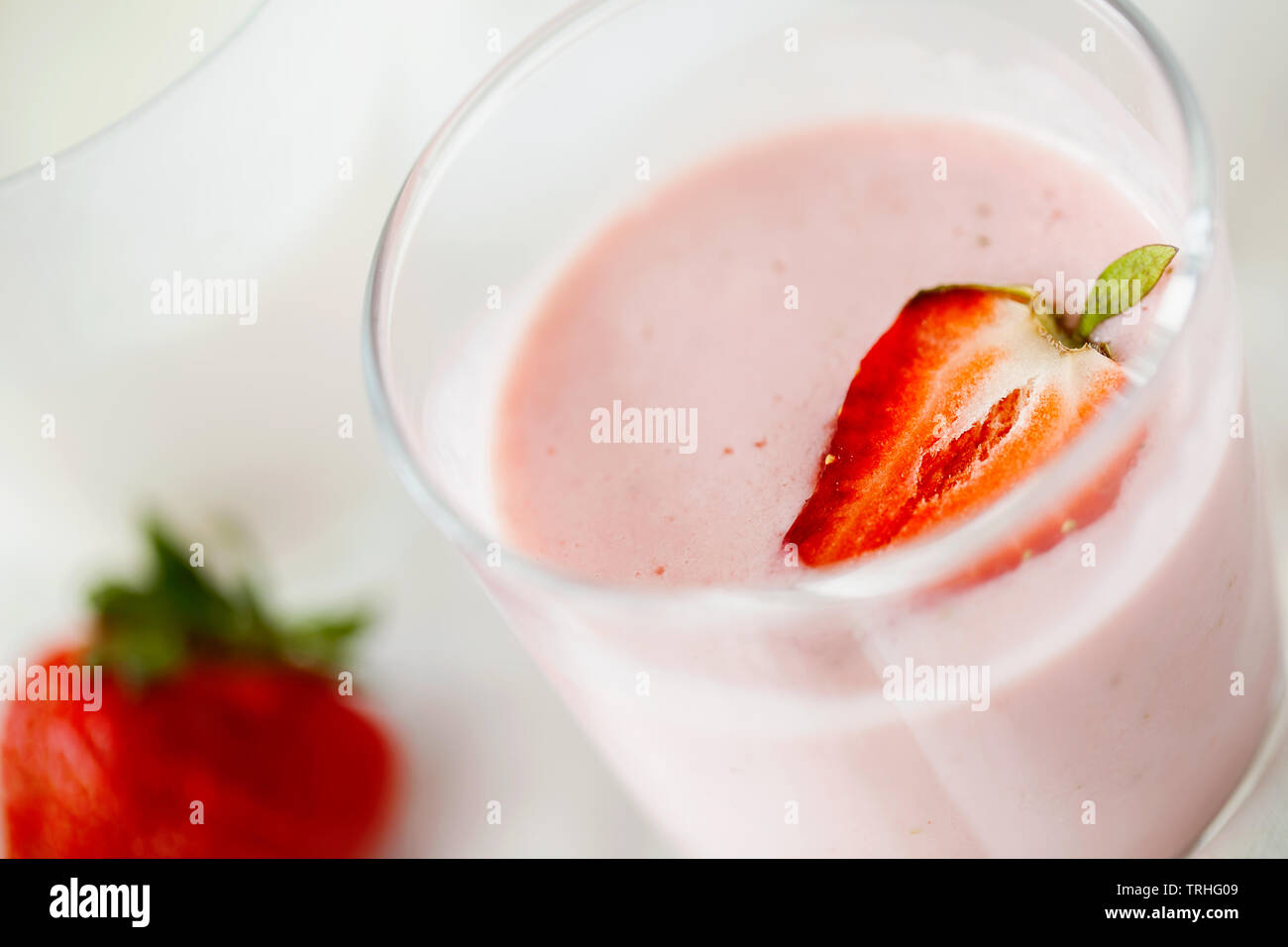 Smoothie aux framboises fraîches bio faits maison avec le kéfir(yaourt, ayran, lassi, produit lacté) de suivre un régime petit déjeuner en verre sur fond blanc close-up Banque D'Images