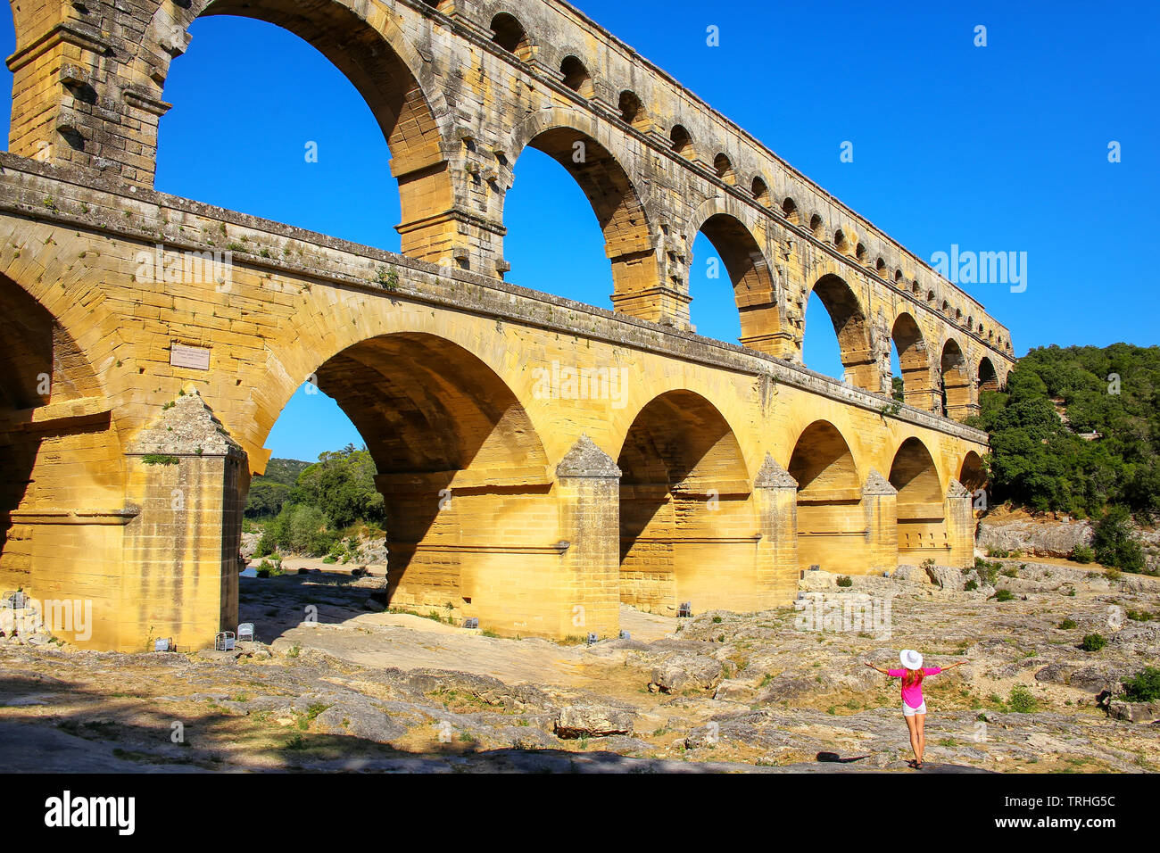 Jeune femme debout près de Aqueduc Pont du Gard dans le sud de la France. Il est le plus élevé de tous les des aqueducs romains. Banque D'Images
