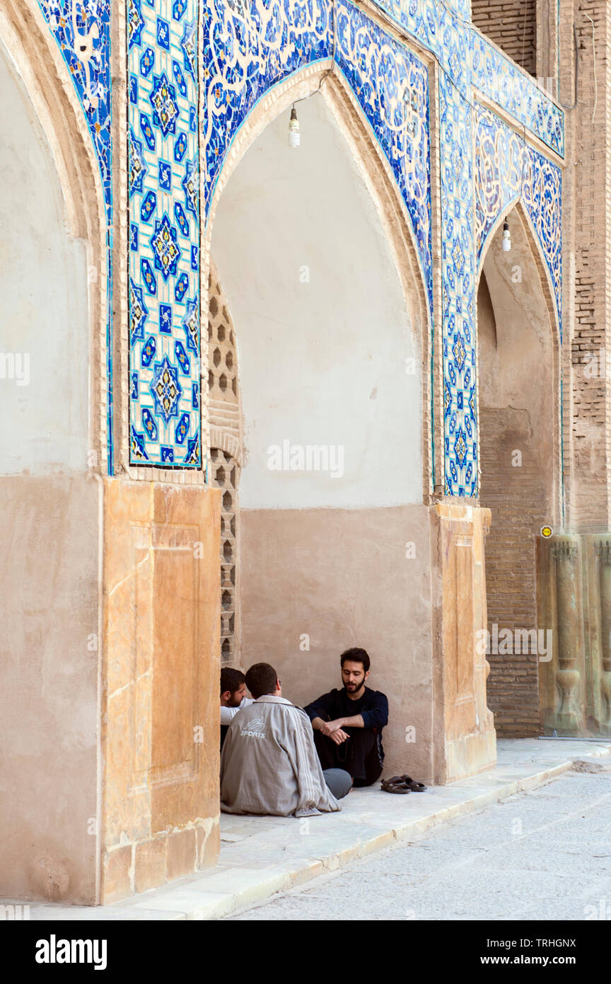 Les hommes assis sous une arche dans la Masjed-e Jame ou Mosquée du Vendredi à Ispahan, en Iran. Banque D'Images