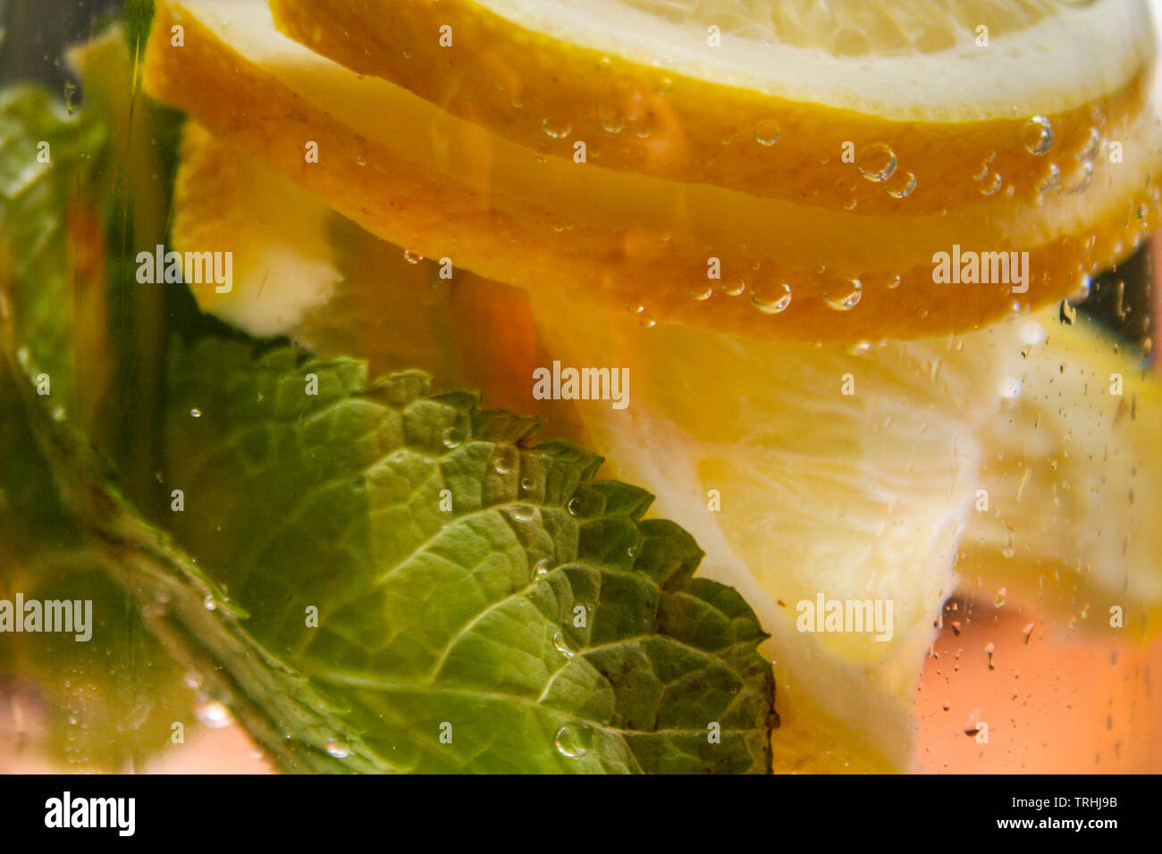 Le flacon en verre avec de l'eau fraîche, de citron et de feuilles de menthe Banque D'Images