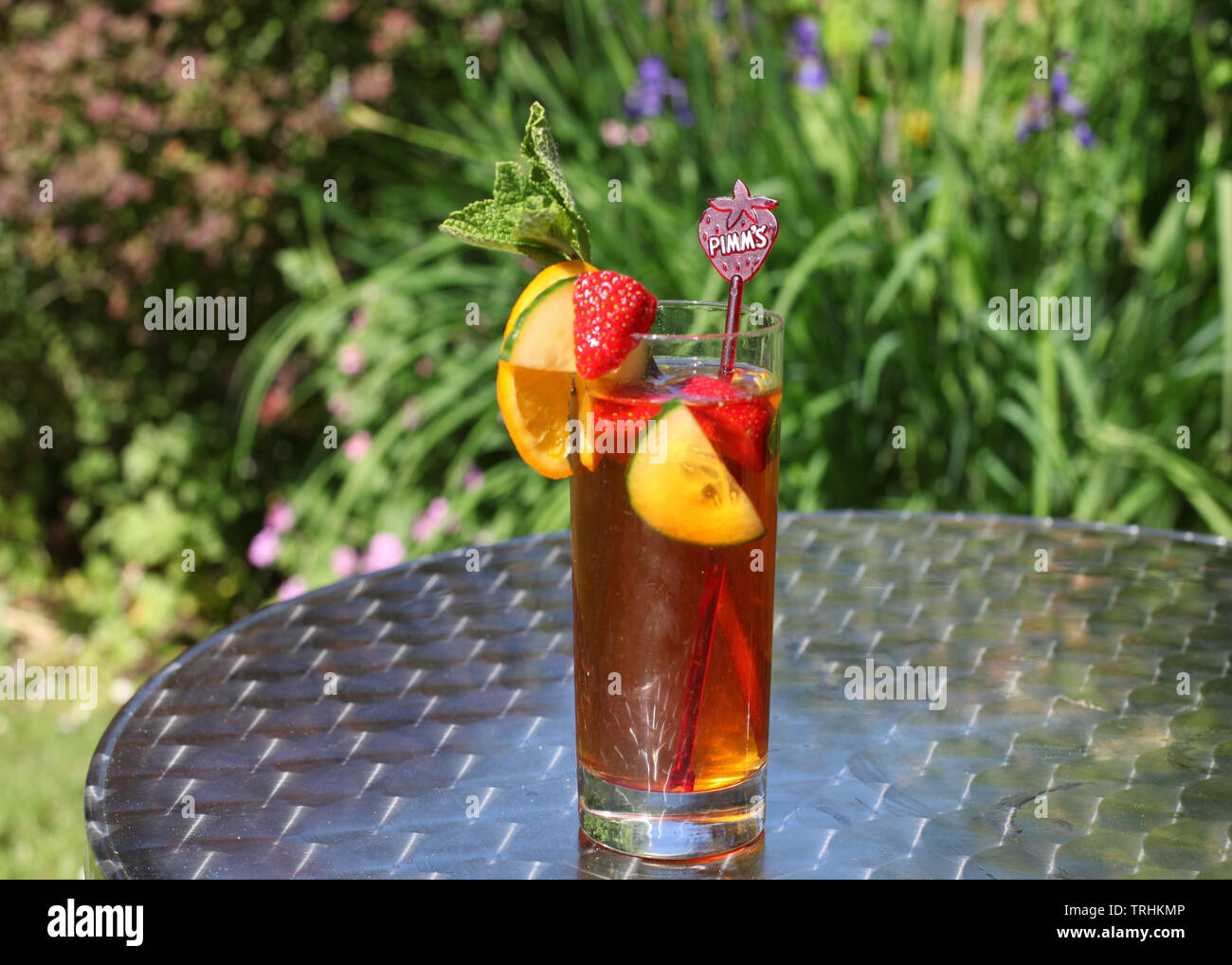 Grand verre de limonade et Pimms sur jardin extérieur silver table de bistro au soleil Banque D'Images