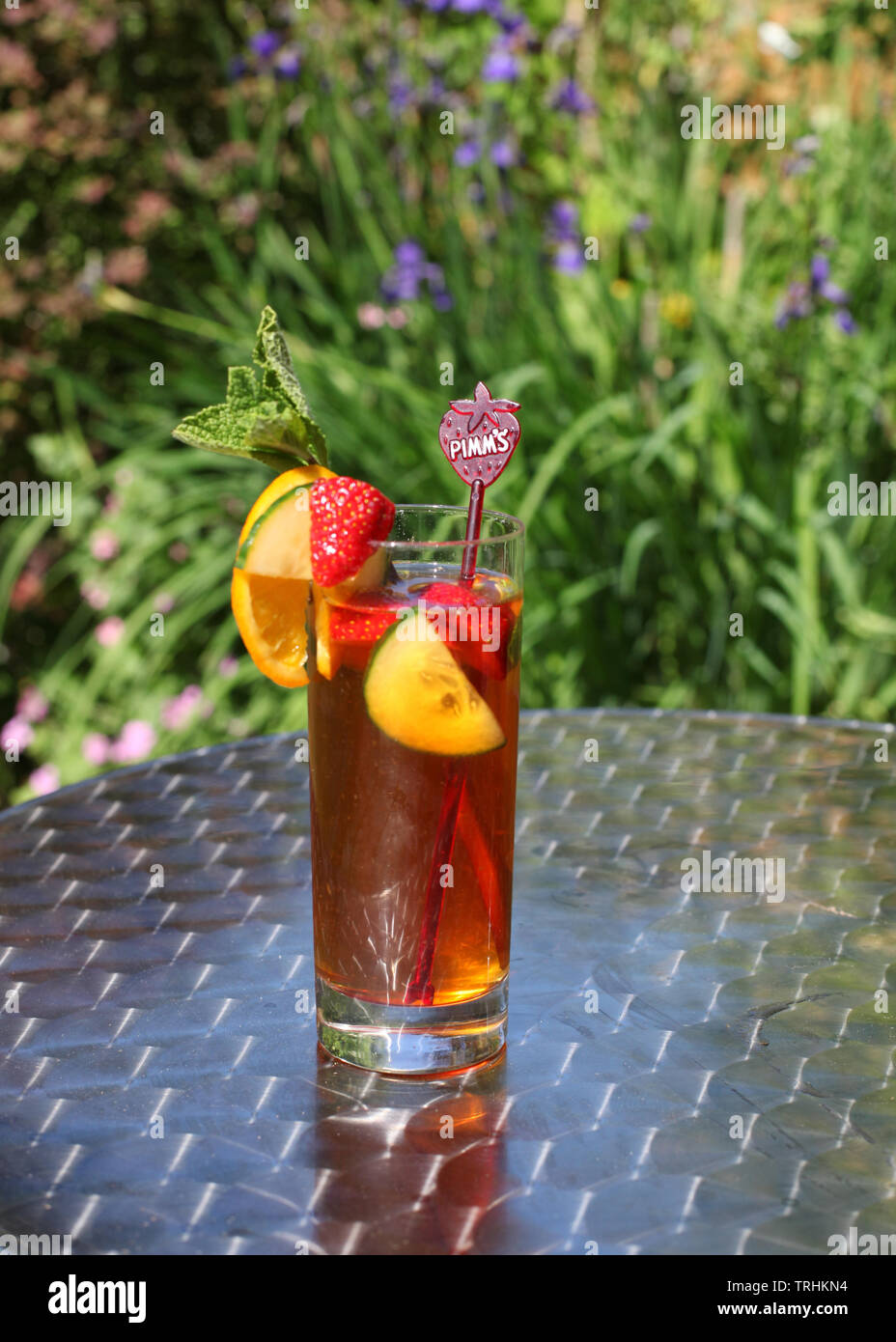 Grand verre de limonade et Pimms sur jardin extérieur silver table de bistro au soleil Banque D'Images