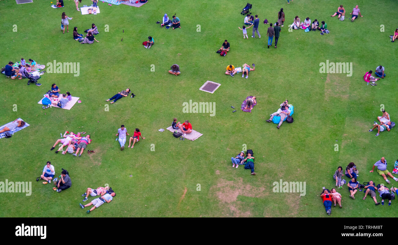Les gens les familles et les couples assis et couché sur la pelouse au repos jardins au bord de la bay de Singapour. Banque D'Images