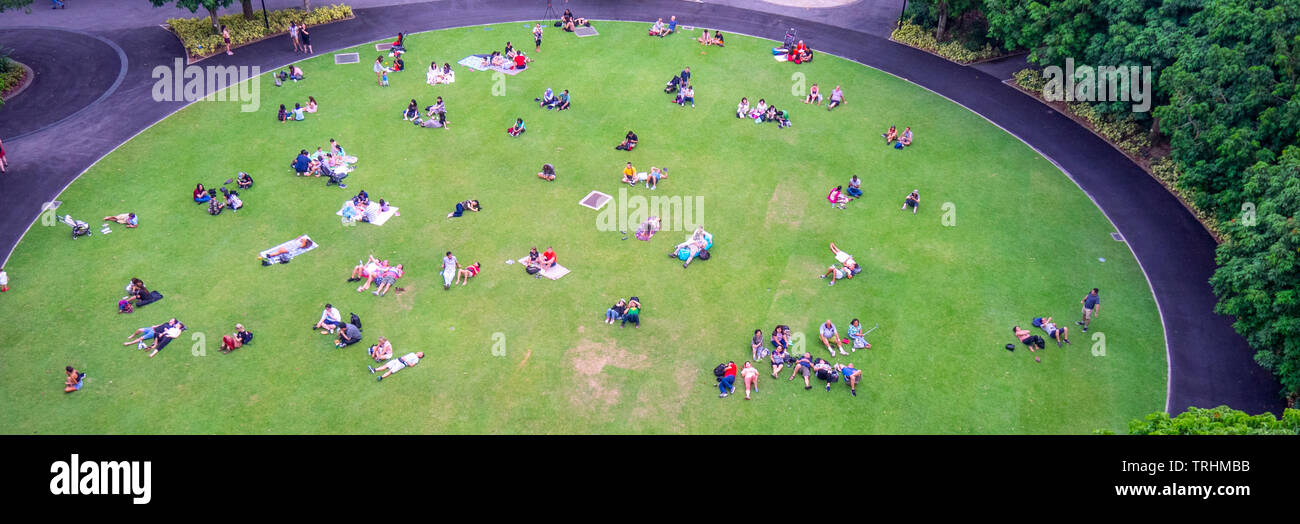 Les gens les familles et les couples assis et couché sur la pelouse au repos jardins au bord de la bay de Singapour. Banque D'Images