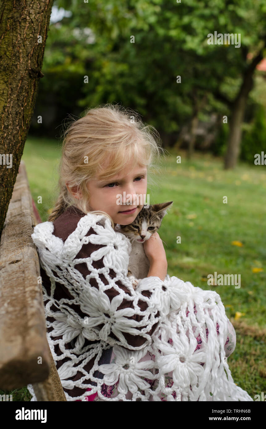 Adorable petite fille blonde holding petit chat animal Banque D'Images