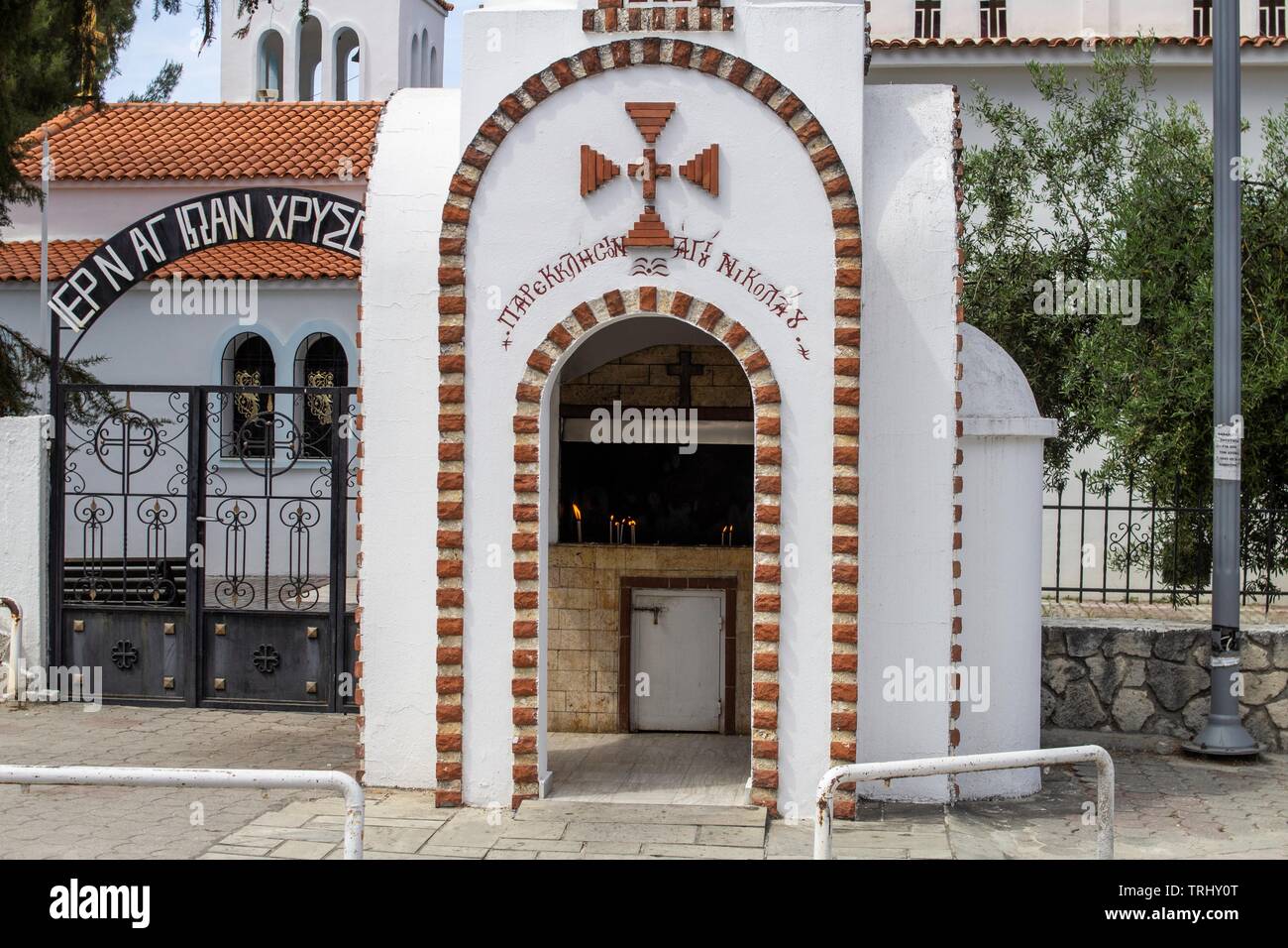 Une petite chapelle à l'extérieur d'une église à Chanioti, Halkidiki, Grèce avec des bougies allumées à l'intérieur. Banque D'Images