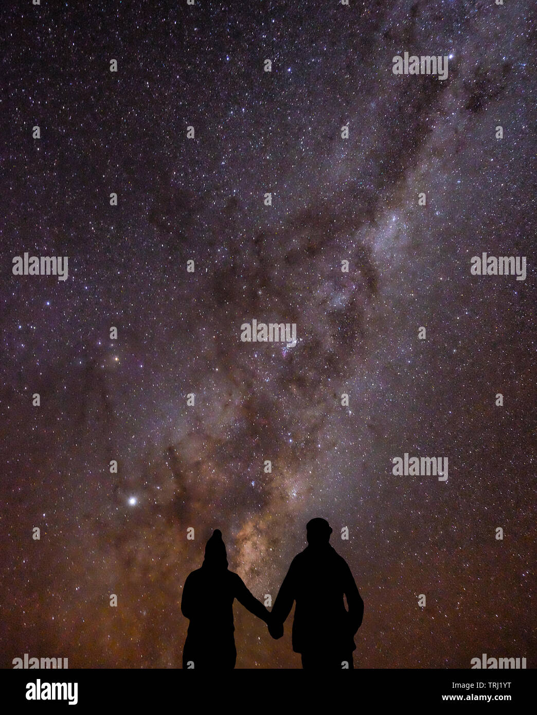 Un couple tenir la main sous les étoiles à l'East Cape, Île du Nord, Nouvelle-Zélande Banque D'Images