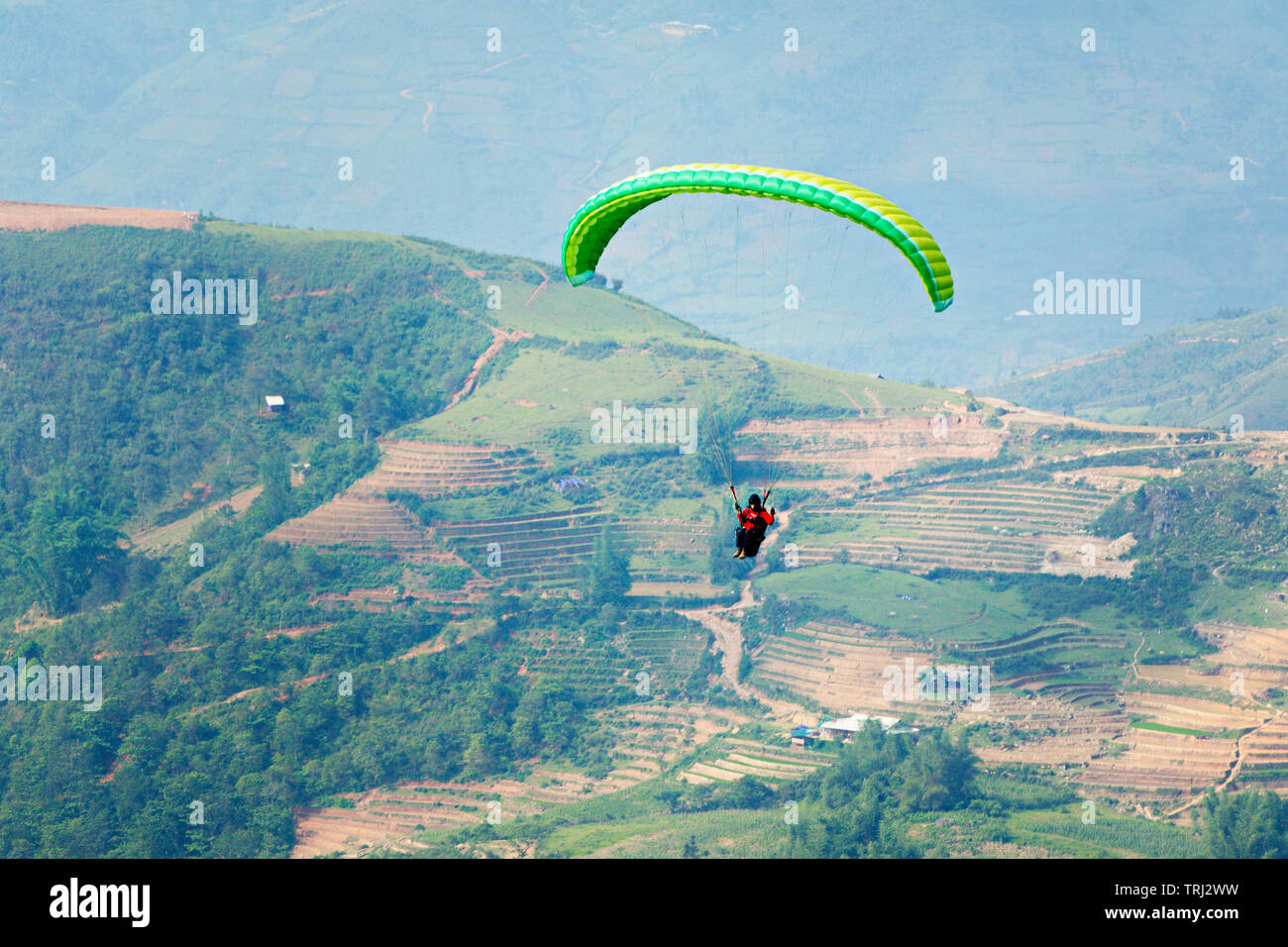 MU CANG CHAI, VIETNAM - Mai 26, 2019 : les touristes parachute sur les terrasses de riz irrigués. C'est un très célèbre site de parapente dans le nord du Vietnam. Banque D'Images