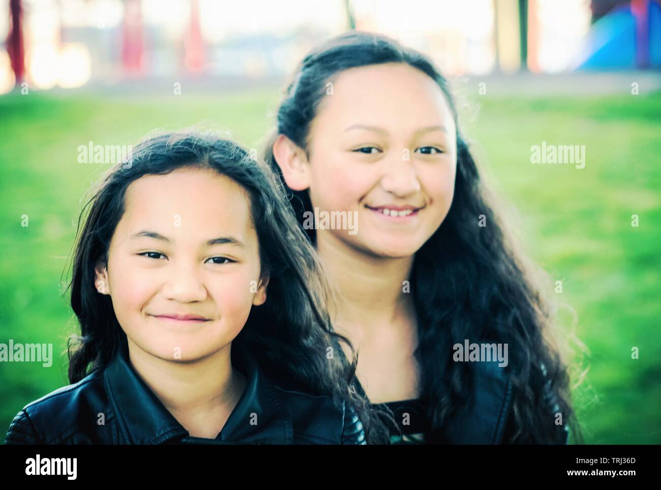 Portrait de deux jeunes sœurs Maori pris à l'extérieur dans un parc. Banque D'Images