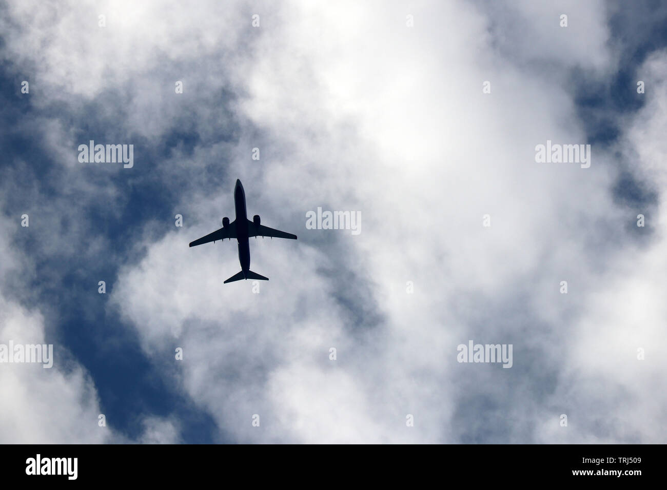 Vol d'un avion dans le ciel sur fond de nuages. Silhouette d'un avion commercial, concept de turbulence Banque D'Images