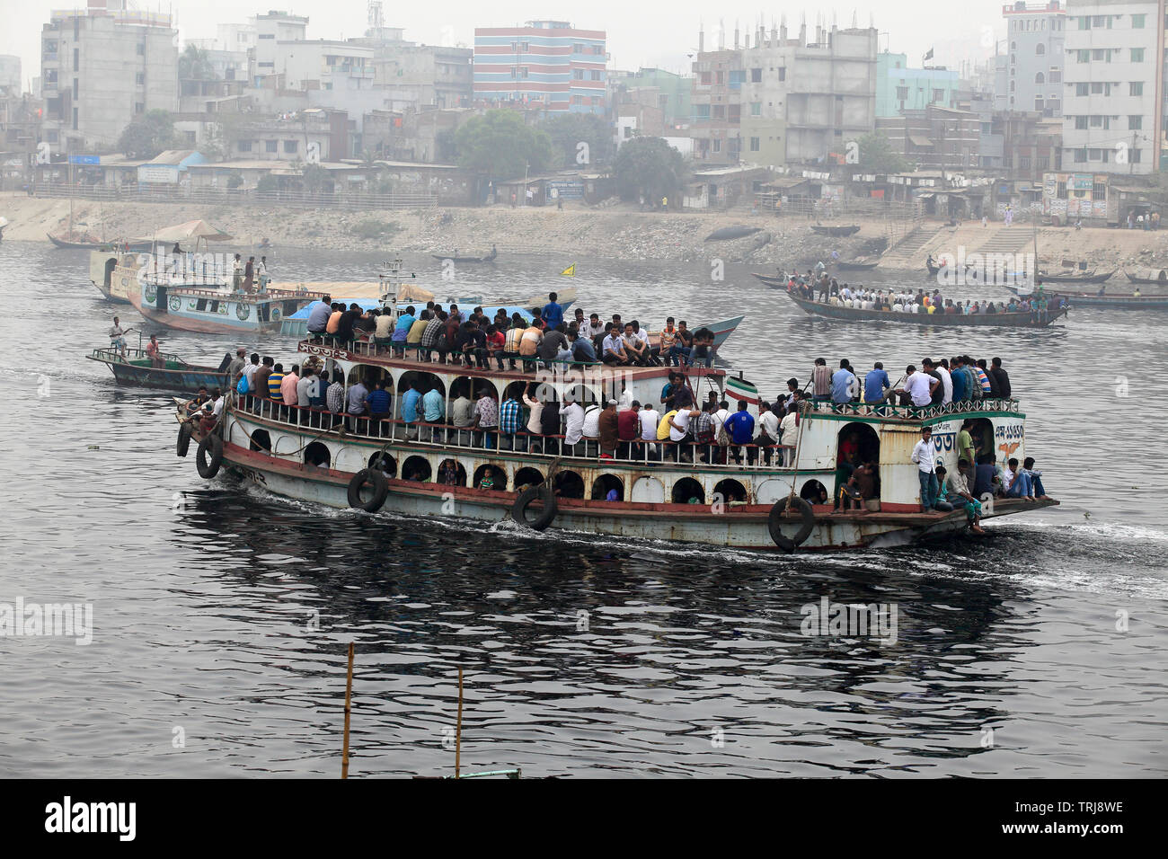 Les gens traversent les eaux polluées de l'visqueux de la rivière Buriganga chaque jour pour arriver à leur destination. Dhaka, Bangladesh. Banque D'Images