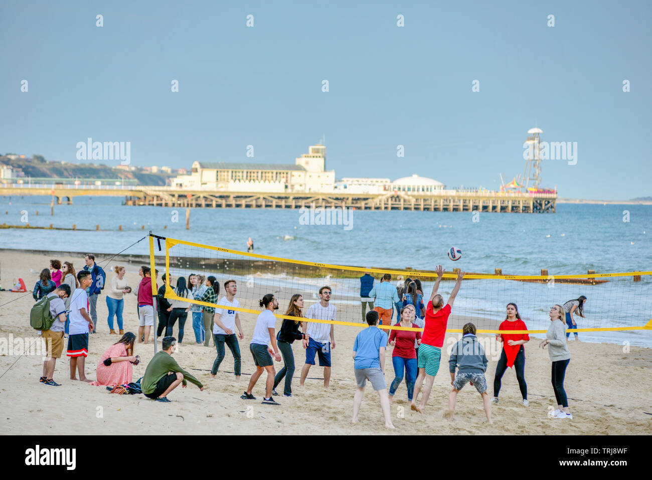 Volley-ball sur la plage de Bournemouth avec la jetée à l'arrière. Le Dorset. Angleterre, Royaume-Uni. Banque D'Images