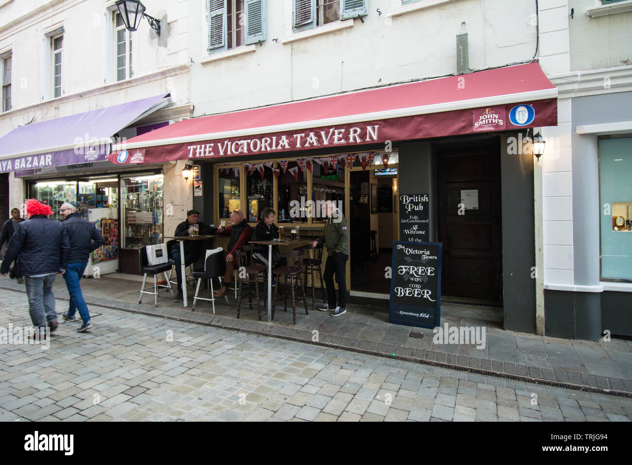 Gibraltar la Victoria Tavern rue principale assis manger des gens craie marche nourriture boisson style de vie signes divertissement cheveux rouges Banque D'Images