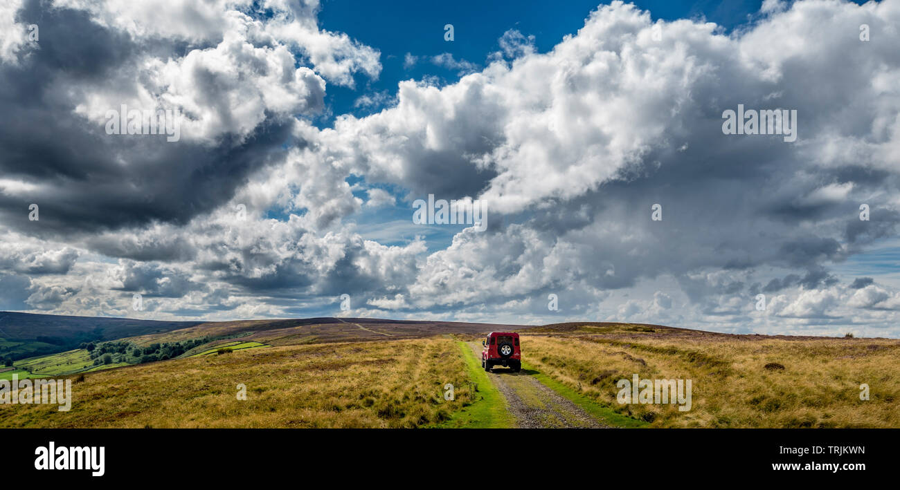 Land Rover Defender 110 rouge 4X4 navigation dans une voie verte voie, North Yorkshire Moors, UK. Banque D'Images