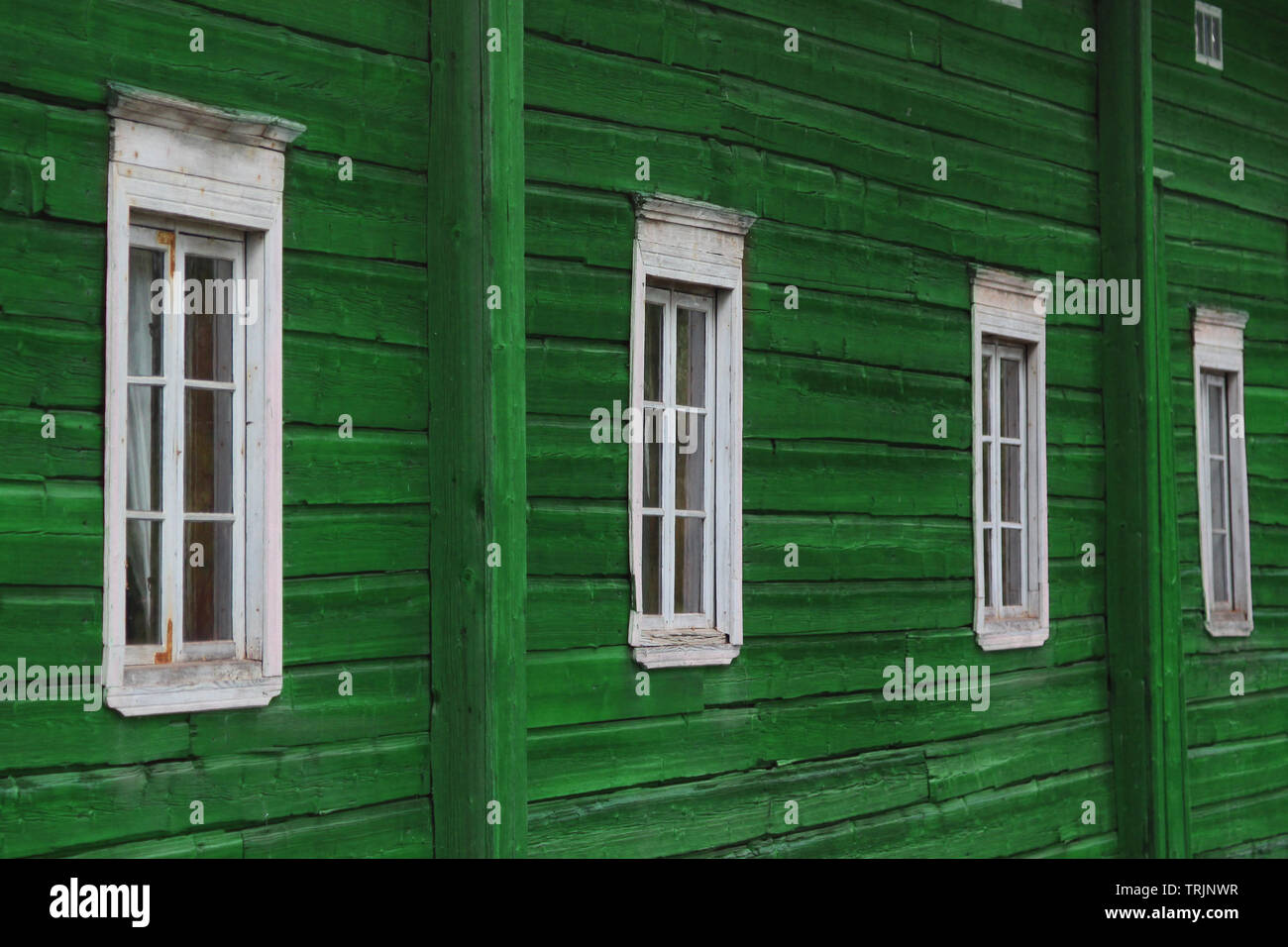 Rangée de fenêtres sur un mur en bois peint vert Banque D'Images