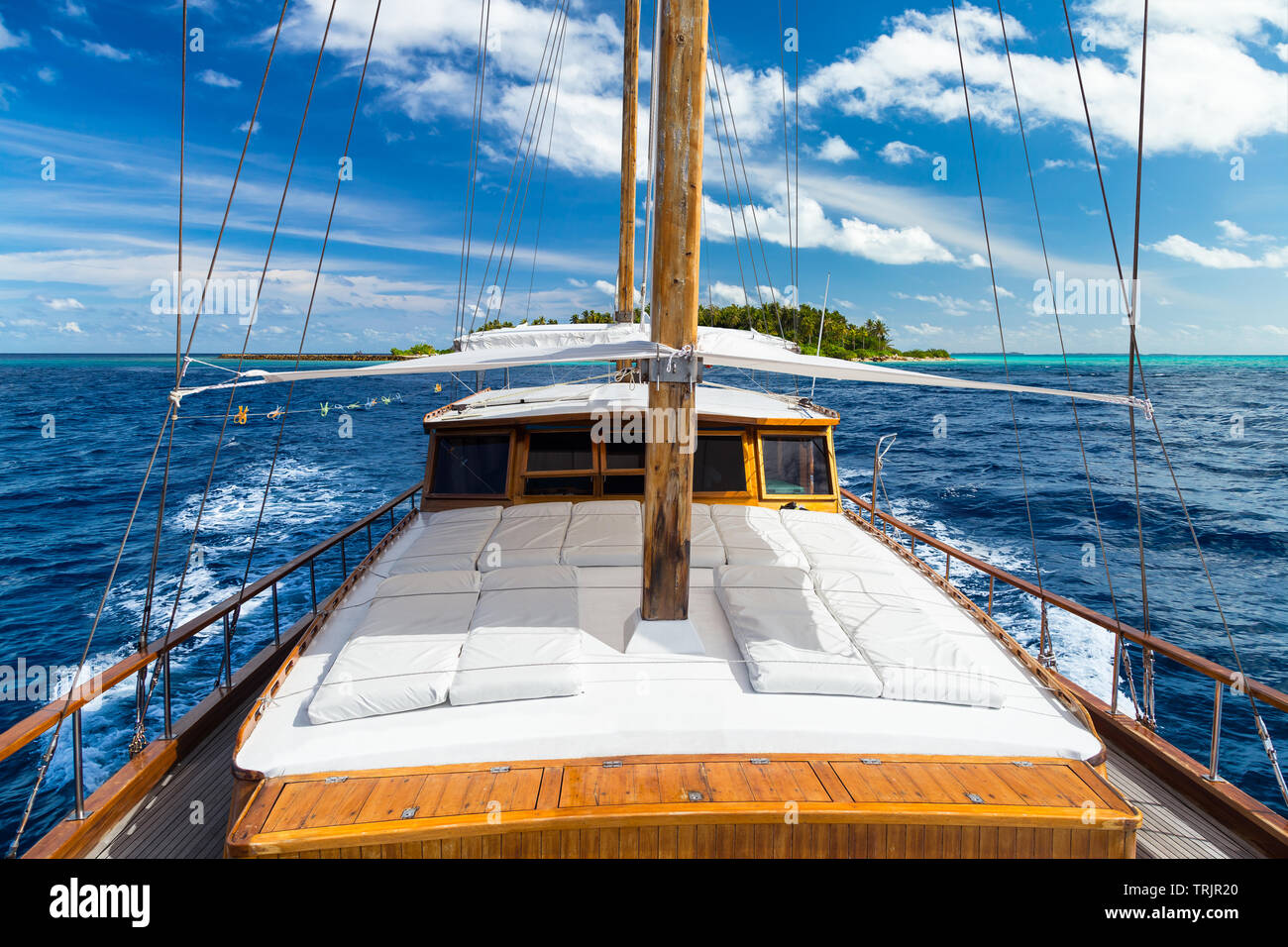 Yacht à voile de luxe en face de tropical Paradise Island resort maldives avec barrière de corail et l'eau de l'océan bleu turquoise fond tourisme Banque D'Images