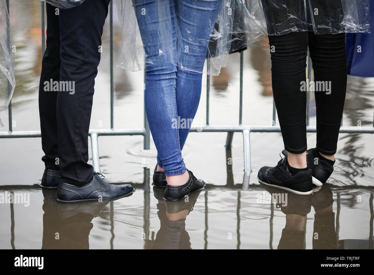 Les détails avec les pieds des jeunes gens debout dans l'eau à un rassemblement public (festival de musique) Banque D'Images