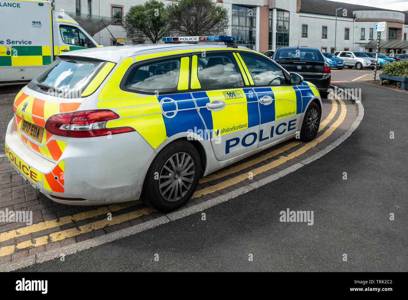 Une voiture de police et une ambulance garé à l'extérieur de l'accident et d'urgence de l'Hôpital universitaire de l'unité de Wishaw, en Écosse. Parking et l'entrée principale. Banque D'Images