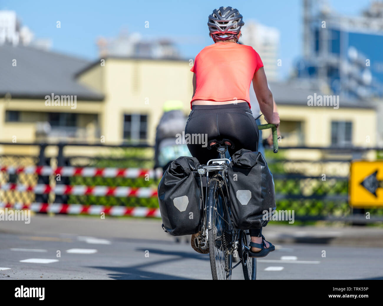 Une superbe femme dans les vêtements de sport cycliste casque et traverse  le carrefour sur une bicyclette, préférant une manière active de détente et  l'aide à garder la sienne Photo Stock -