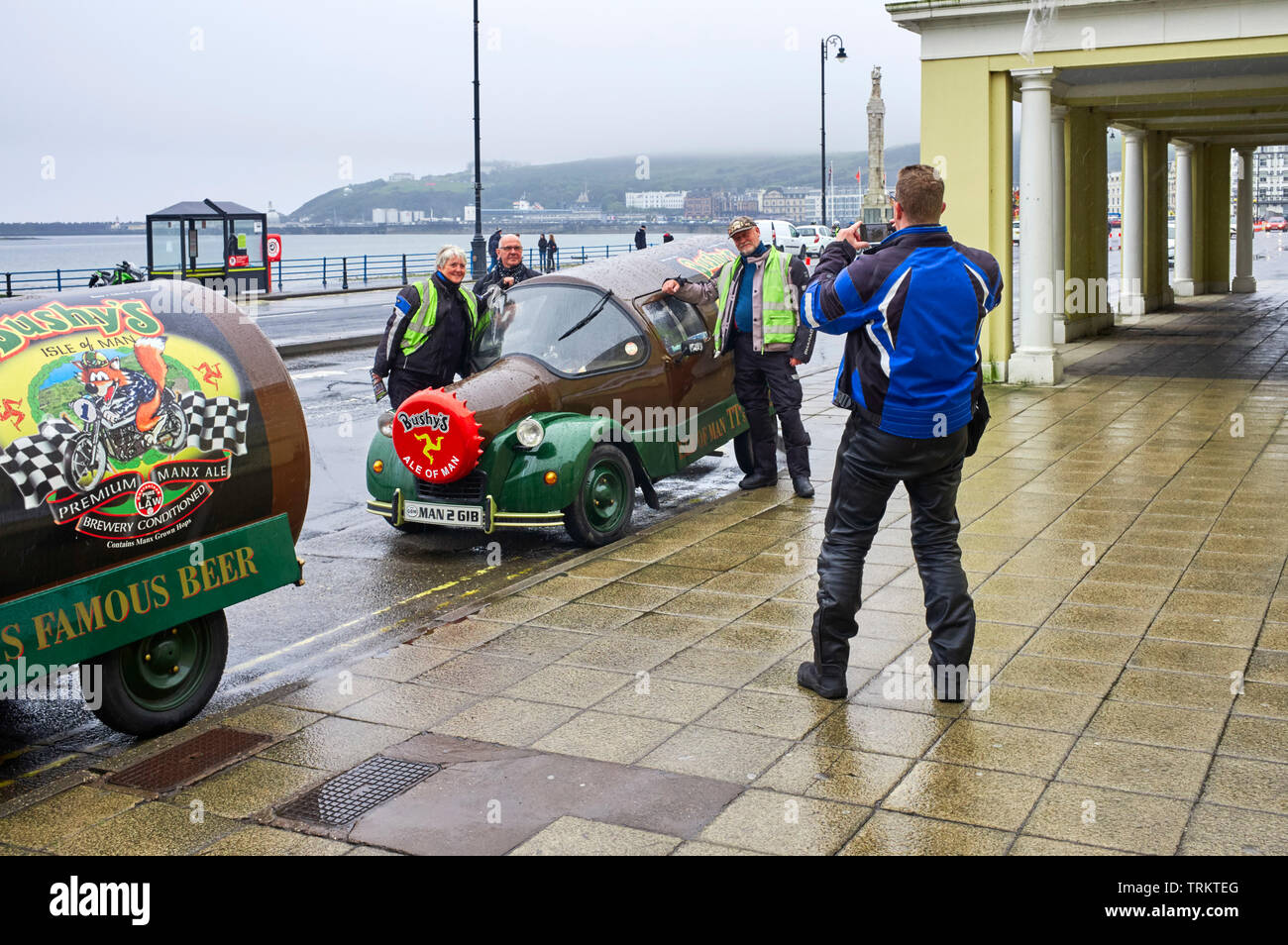 En visitant les goers de course de TT qui se posent sous la pluie par l'une des célèbres voitures de bouteille de Bushy, Douglas, île de Man Banque D'Images