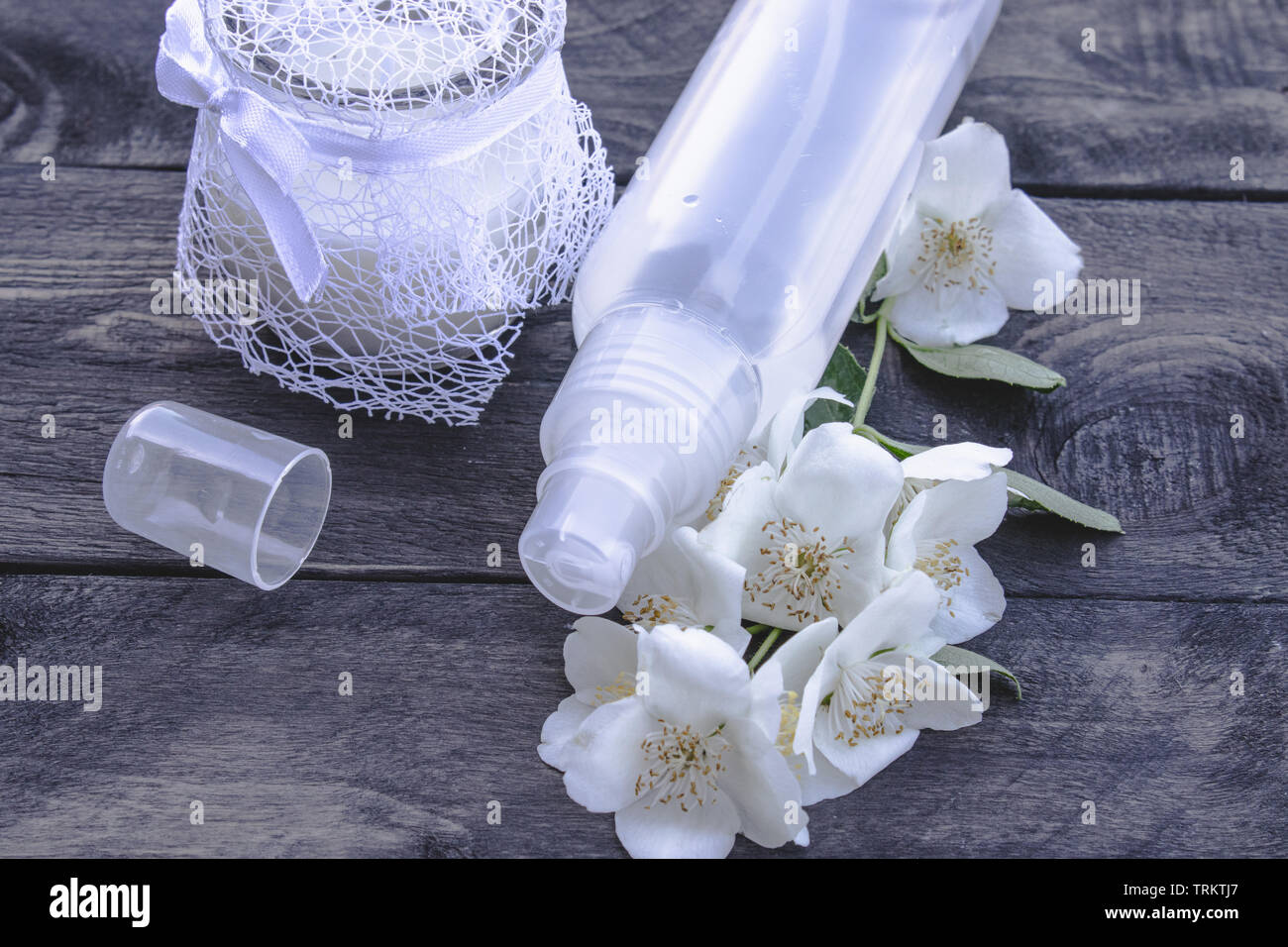 Jasmine esthétique de l'eau dans une bouteille sur un fond sombre. Procédures cosmétiques Banque D'Images