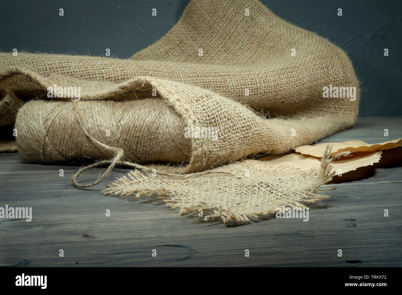 Bobines de fils de toile de jute, ficelle ou un sac en tissu sur fond gris rustique Banque D'Images