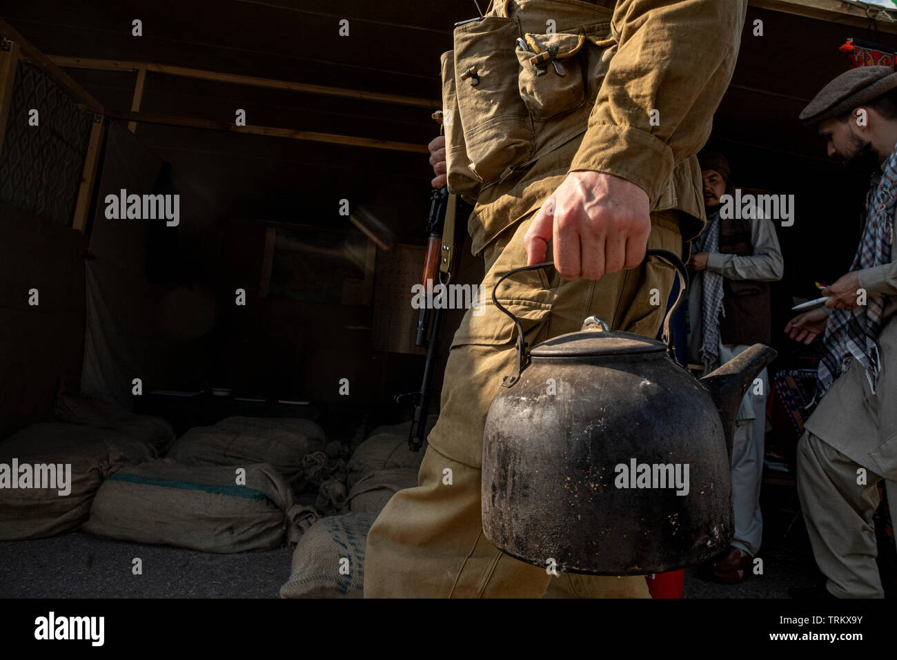 Soldat de l'armée soviétique va avec une bouilloire sur le village afghan lors de la guerre d'Afghanistan (1979-1989). Reconstitution historique de la vie de l'armée soviétique Banque D'Images