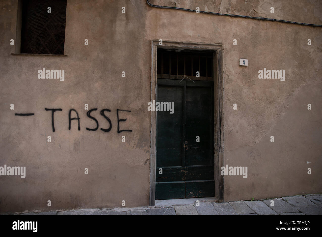 Écrit sur un mur pour demander moins d'impôts. Albenga, en Ligurie, Italie Banque D'Images